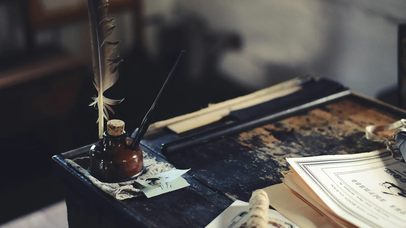 Encrier et plume sur un bureau ancien, dans la pénombre