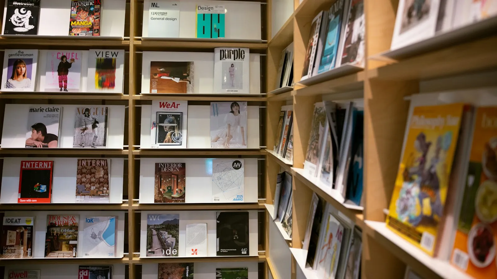 Rayon de magazines et de livres sur des étagères en bois
