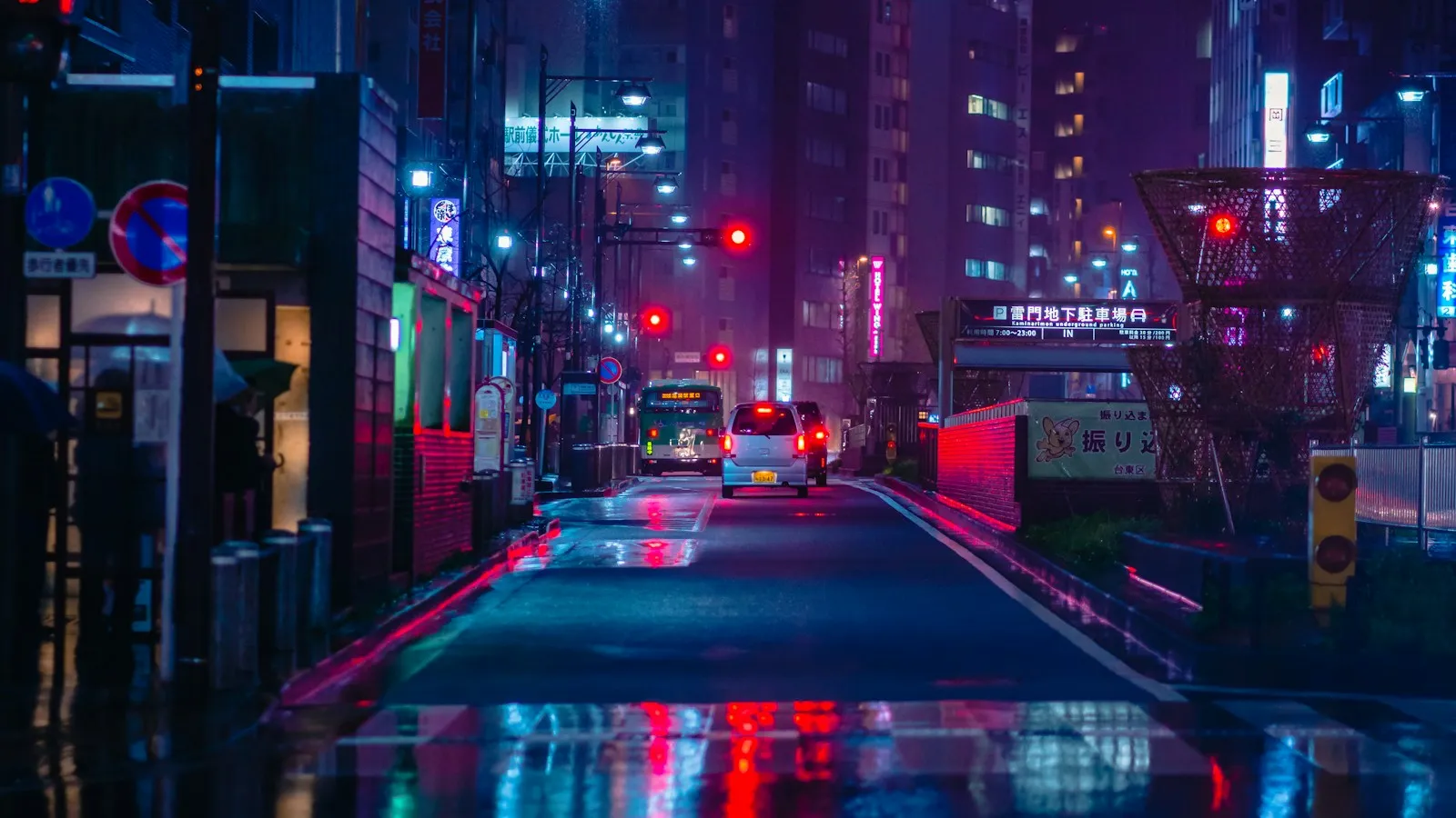 Rue de Tokyo la nuit, enseignes au néon réfléchies sur la chaussée mouillée