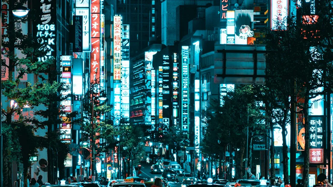 Avenue de Tokyo bordée d’enseignes verticales illuminées